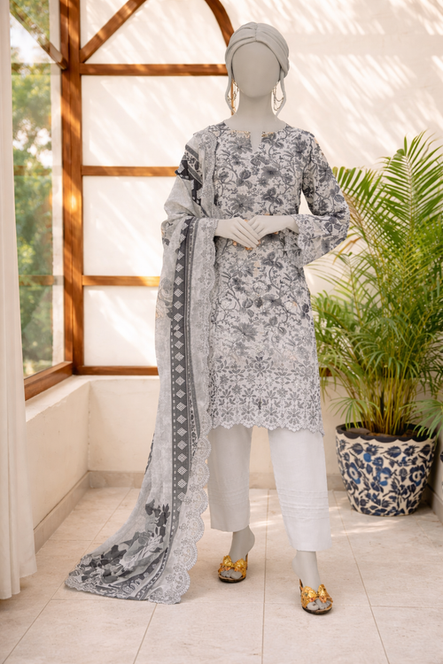 Mannequin wearing a floral dress with a long scarf in a bright room with plants.