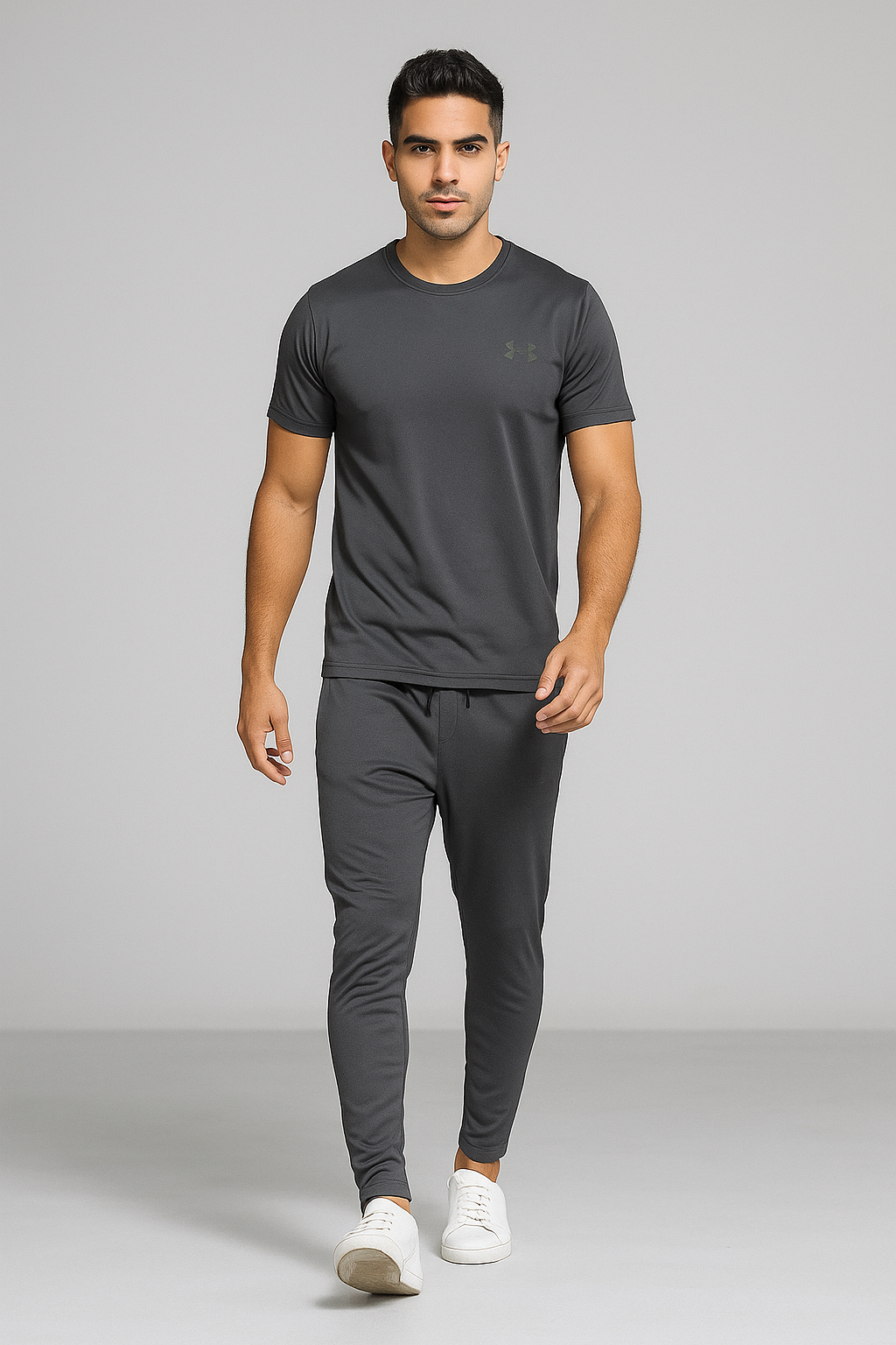 Man wearing a gray athletic outfit with Under Armour logo on a gray background