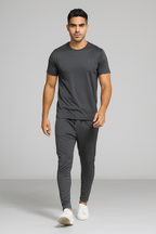 Man wearing a gray athletic outfit with Under Armour logo on a gray background