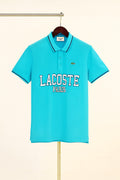 aqua Lacoste polo shirt on a hanger against a beige background