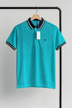 aqua polo shirt with black coller on a hanger against a gray background