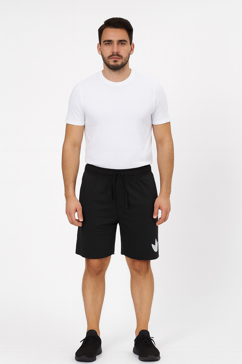 Man wearing a white t-shirt and black shorts on a white background