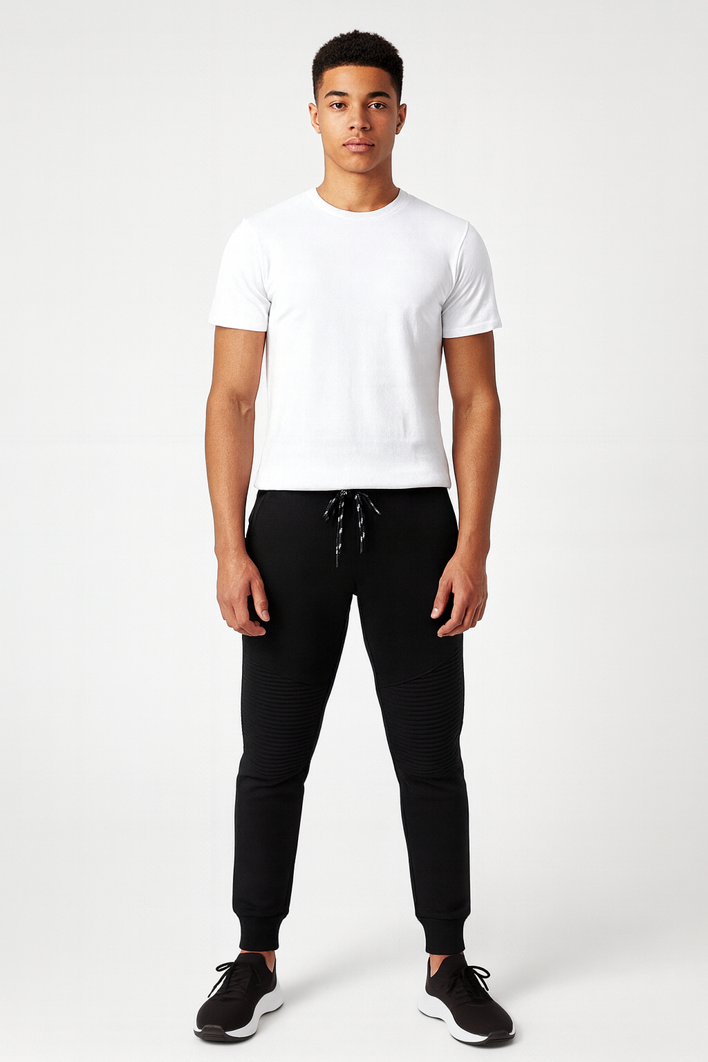 Person wearing a white t-shirt and black pants on a white background