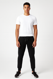 Person wearing a white t-shirt and black pants on a white background