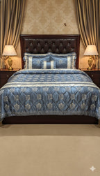Decorative bedspread with blue and white patterns on a bed in a bedroom setting.