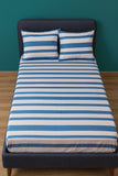 Bed with blue and white striped bedding against a teal wall