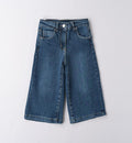 A pair of blue bell-bottom jeans for girls laid flat on a white background.