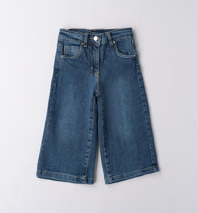 A pair of blue bell-bottom jeans for girls laid flat on a white background.
