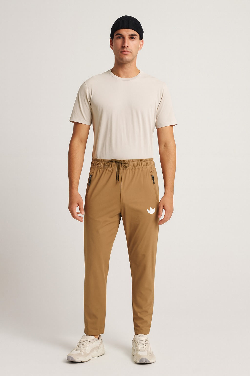 Man wearing a camel  t-shirt and brown pants with a logo on a white background