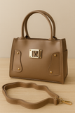 coffe handbag with gold accents on a wooden surface