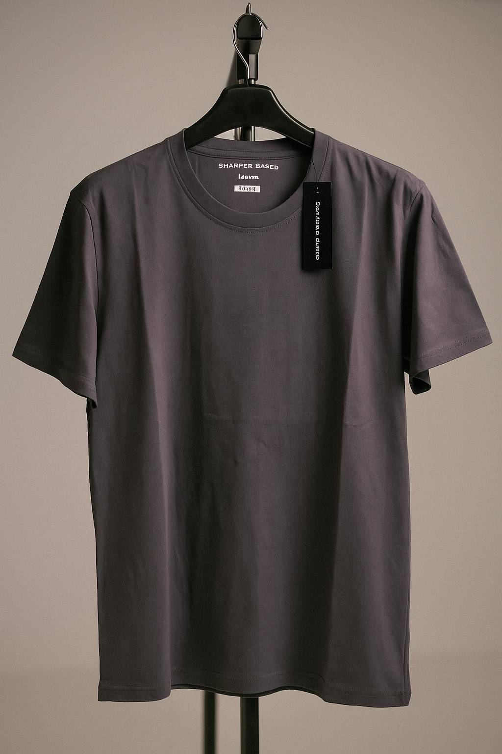 dark Gray t-shirt on a hanger with a visible brand tag against a neutral background