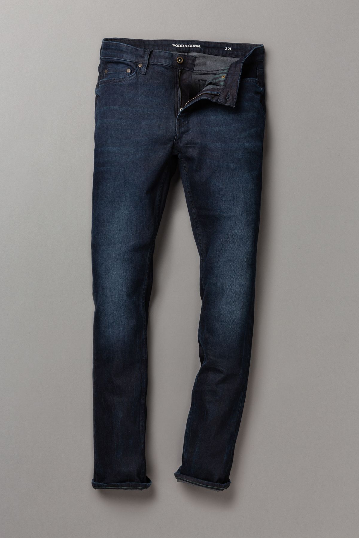 Pair of dark blue jeans on a light gray background