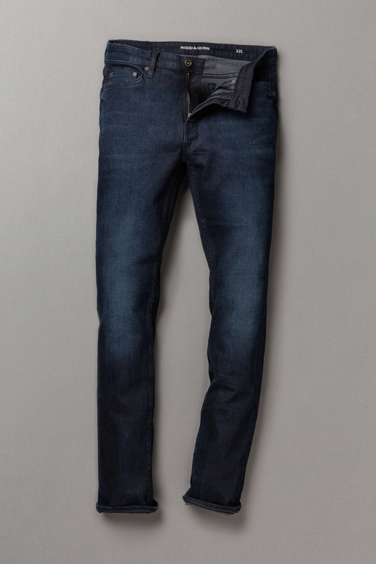 Pair of dark blue jeans on a light gray background