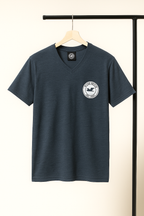 dark gray blue t-shirt with a logo on a hanger against a neutral background
