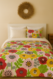 Bed with colorful floral bedding and a decorative wreath on the wall.
