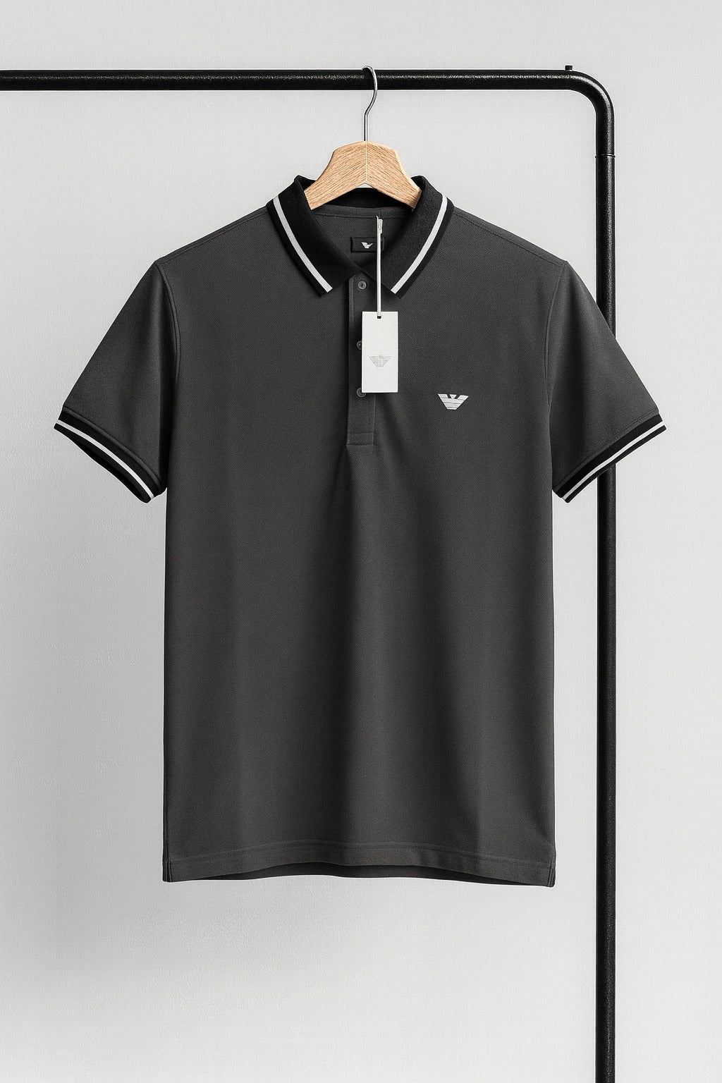 gray polo shirt with white coller on a hanger against a gray background