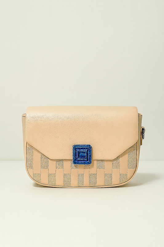 Beige handbag with a blue decorative element on a light beige background