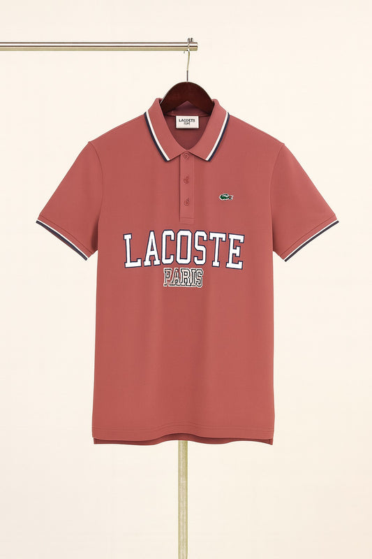 lite peach Lacoste polo shirt on a hanger against a beige background