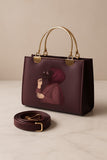 maroon handbag with gold accents and a matching strap on a beige background