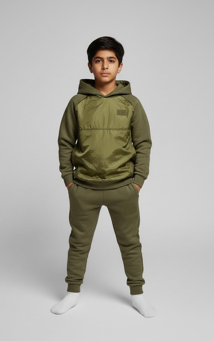 Person wearing an olive green hoodie and pants on a light gray background