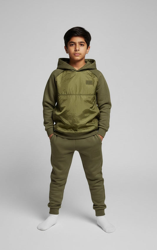 Person wearing an olive green hoodie and pants on a light gray background