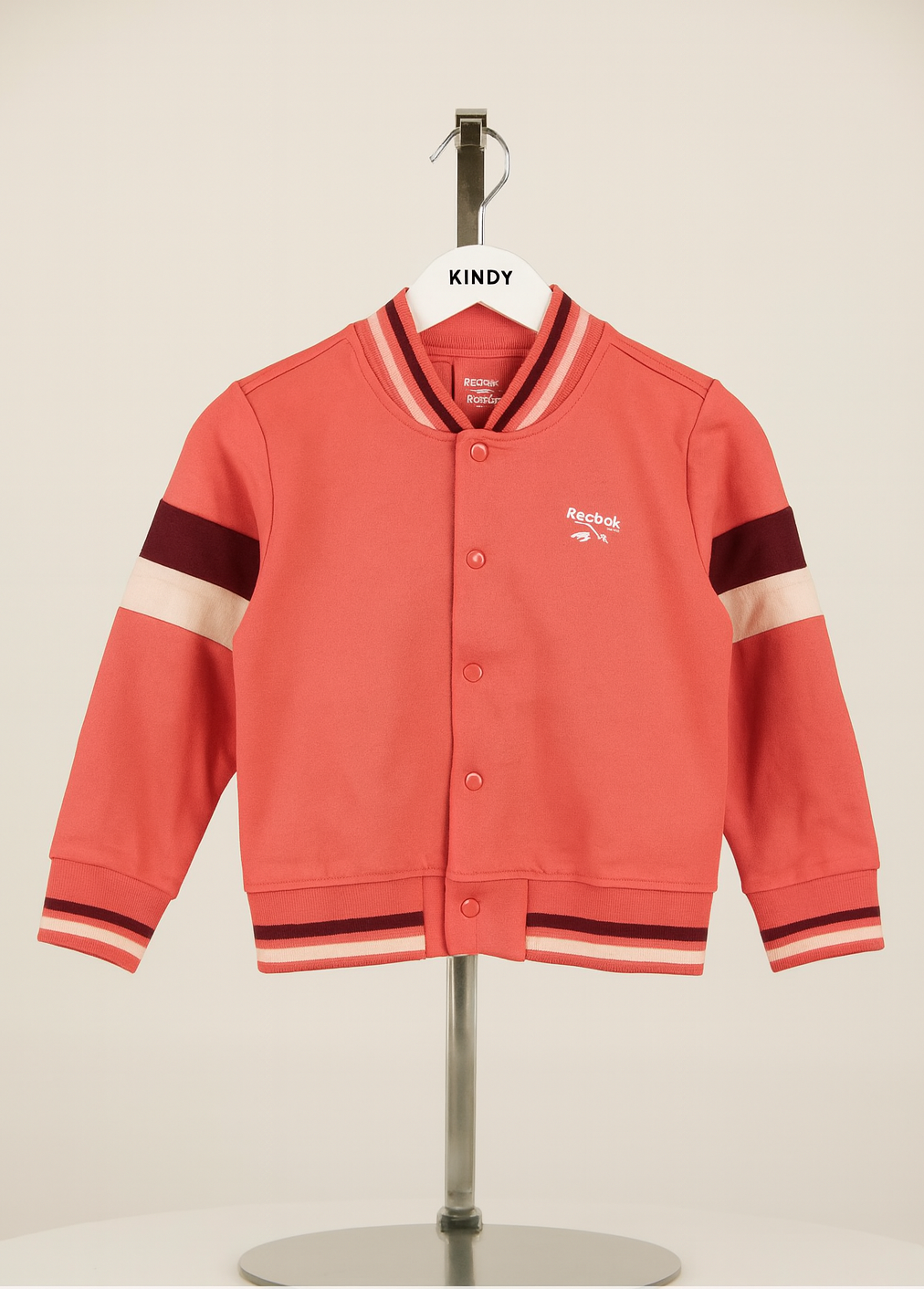 orange rvarsity jacket with black and white accents on a mannequin against a beige background