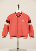 orange rvarsity jacket with black and white accents on a mannequin against a beige background