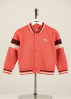 orange rvarsity jacket with black and white accents on a mannequin against a beige background