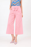 Person wearing pink pants with a bow detail on a white background