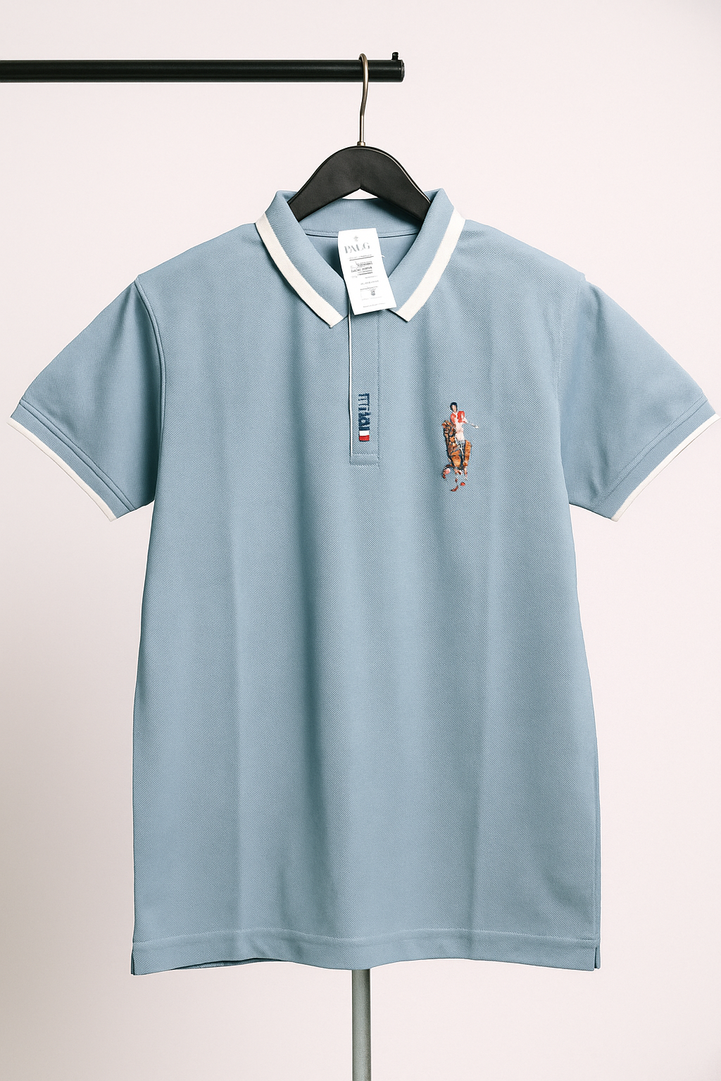 Light blue polo shirt with a brand logo on a hanger against a white background