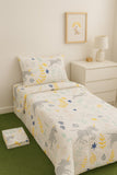 Children's dinosaur-themed bed set on a bed in a room with a lamp and nightstand.