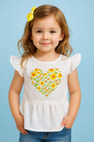 Child wearing a white top with a floral heart design on a blue background