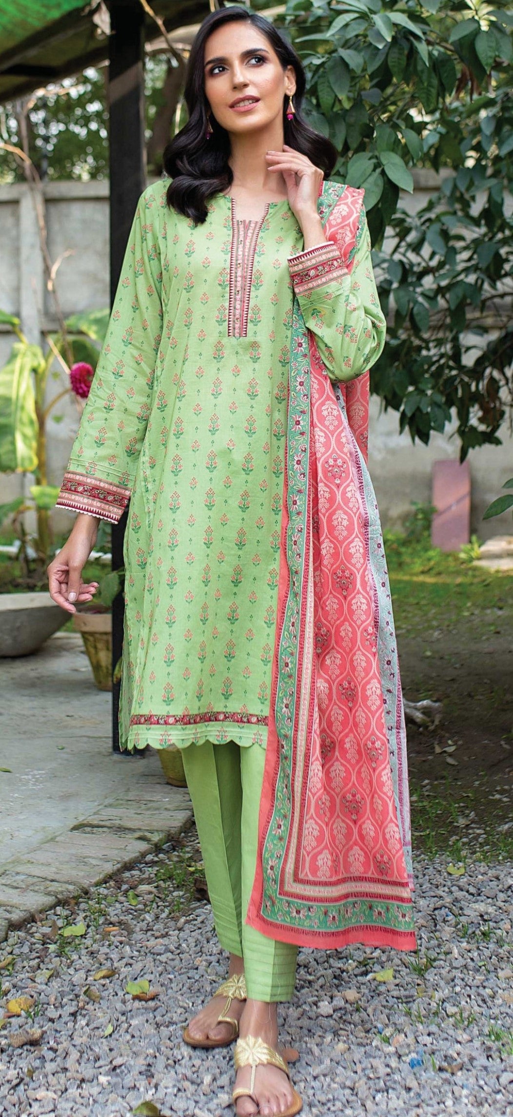 Woman wearing a zeen green and pink traditional outfit with a patterned dupatta outdoors.