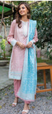 Woman wearing a pink and blue traditional outfit with a garden background